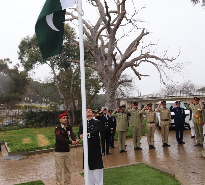 A group of people standing around a flag

Description automatically generated