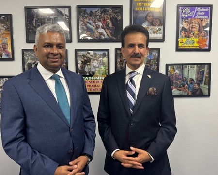 Two men in suits standing in front of a wall of pictures

AI-generated content may be incorrect.