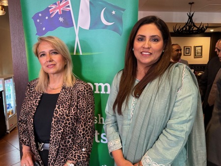 A group of women standing in front of a banner

Description automatically generated