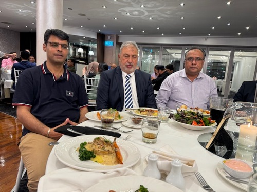 A group of men sitting at a table with food

Description automatically generated