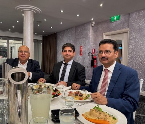 A group of men sitting at a table with food

Description automatically generated