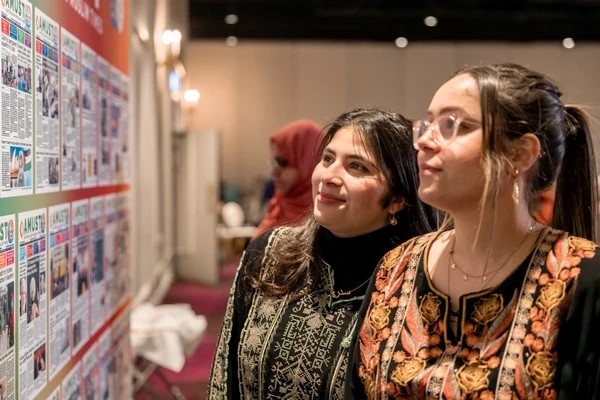 A group of women looking at a poster

Description automatically generated