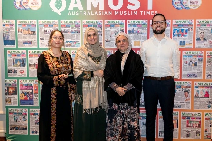 A group of people standing in front of a wall with newspaper

Description automatically generated