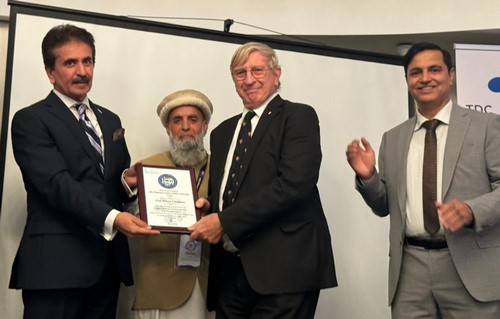 A group of men holding a plaque

Description automatically generated