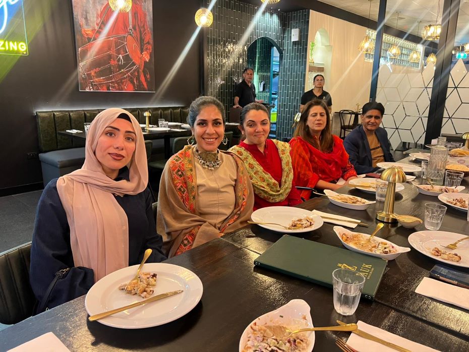 A group of women sitting at a table with plates of food

AI-generated content may be incorrect.