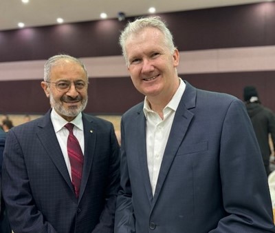 Two men in suits smiling

Description automatically generated