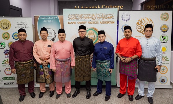 A group of men standing in front of a sign

Description automatically generated