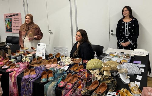 A group of women standing next to a table with shoes

Description automatically generated