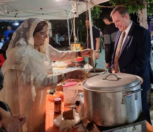 A person in a white dress serving food

Description automatically generated