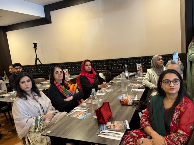 A group of women sitting at a long table

Description automatically generated