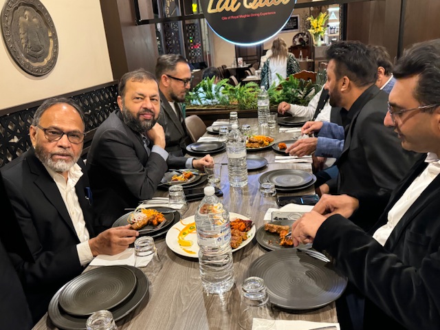 A group of men sitting at a table eating food

Description automatically generated