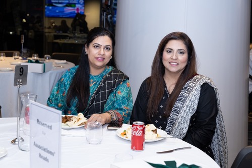 A couple of women sitting at a table

Description automatically generated