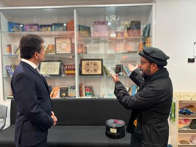 Two men standing in front of a glass display

Description automatically generated