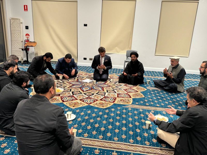 A group of men sitting on a rug

Description automatically generated