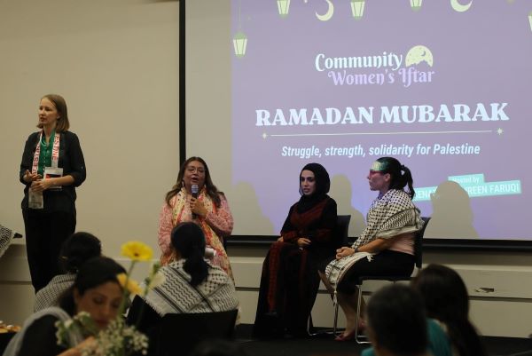 A group of women speaking in front of a projection screen

Description automatically generated