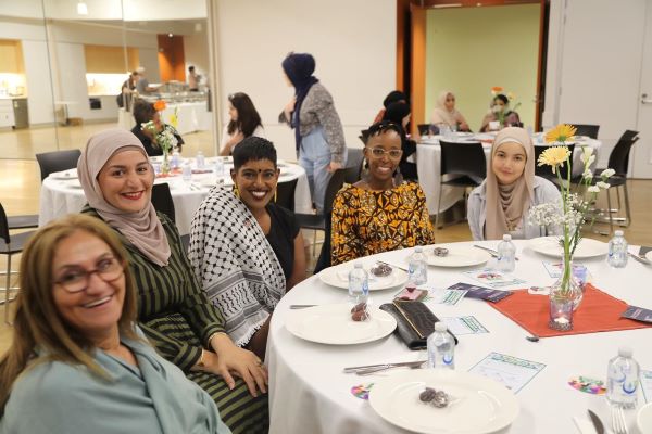 A group of women sitting at a round table

Description automatically generated