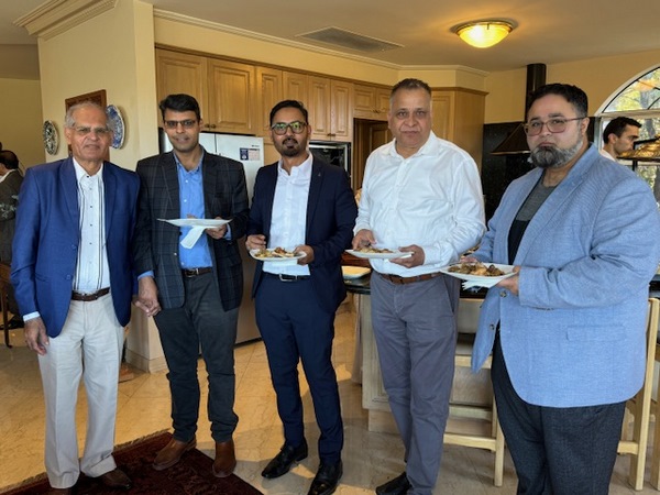 A group of men holding plates of food

Description automatically generated