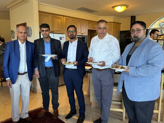 A group of men holding plates of food

Description automatically generated