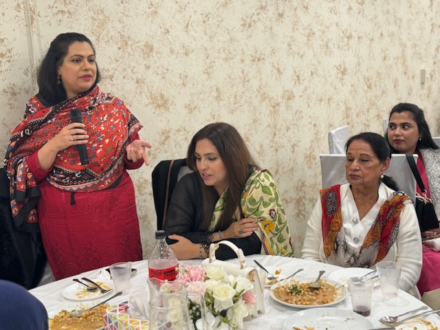 A person speaking to a group of women sitting at a table

Description automatically generated