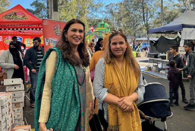 A couple of women standing in a street

Description automatically generated