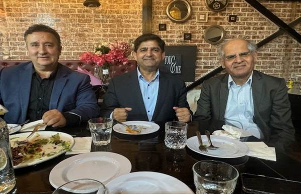 A group of men sitting at a table with plates and glasses

Description automatically generated