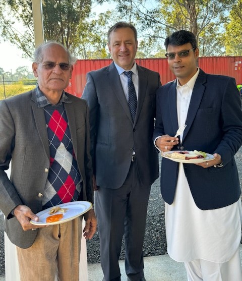 A group of men holding plates of food

Description automatically generated