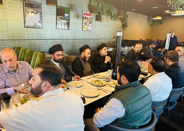 A group of men sitting at a table eating food

Description automatically generated