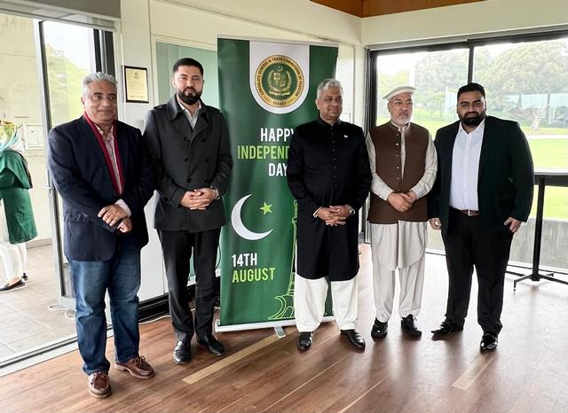 A group of men standing in front of a banner

Description automatically generated