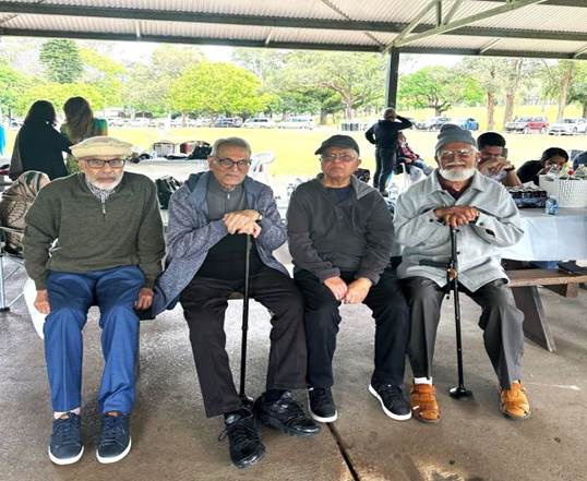 A group of men sitting on a bench

Description automatically generated