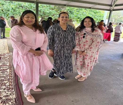 A group of women standing under a canopy

Description automatically generated