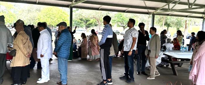 A group of people standing under a covered area

Description automatically generated