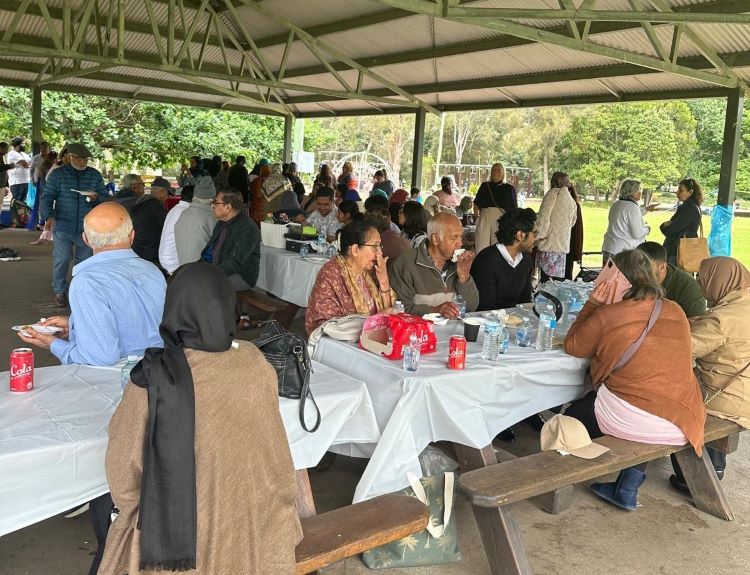 A group of people sitting at tables under a canopy

Description automatically generated