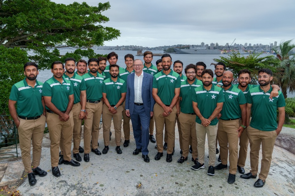 A group of men in green shirts

Description automatically generated