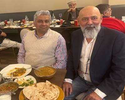 A group of men sitting at a table with food

Description automatically generated