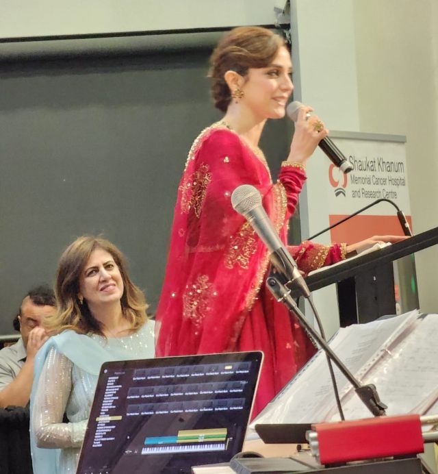 A person in a red dress holding a microphone

AI-generated content may be incorrect.