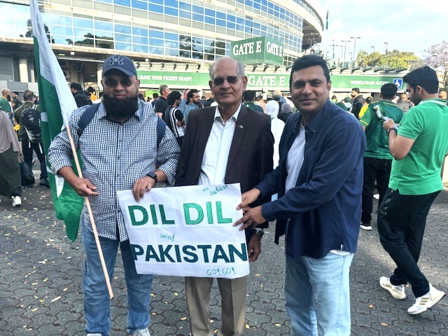 A group of men holding a sign

Description automatically generated