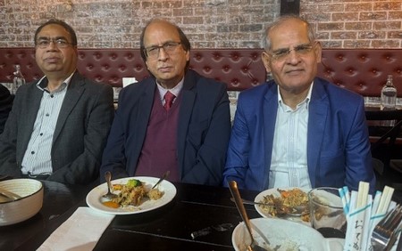 A group of men sitting at a table with plates of food

Description automatically generated