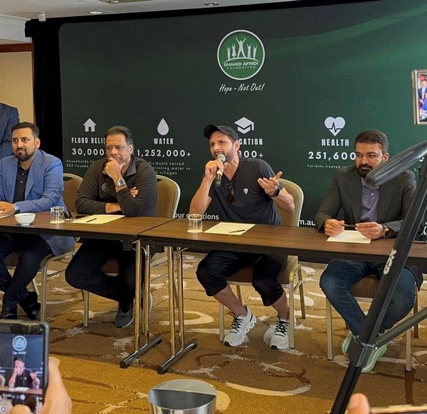 A group of men sitting at a table with microphones

Description automatically generated