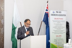 A person standing at a podium with flags behind him

Description automatically generated